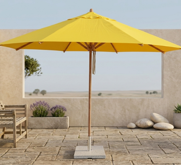 Bambrella Levante 4.0m Round Umbrella – Bright Yellow Shade on Stone Patio The Bambrella Levante 4.0m round umbrella in vibrant yellow, mounted on a wood pole with a square weighted base, providing wide shade over a stone patio next to a teak bench and potted succulents.